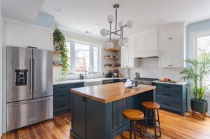 Transitional Washington DC kitchen renovation featuring white and green cabinetry, natural white oak floors, white oak island countertop, and pendant lighting by Hammer Design Build Remodel